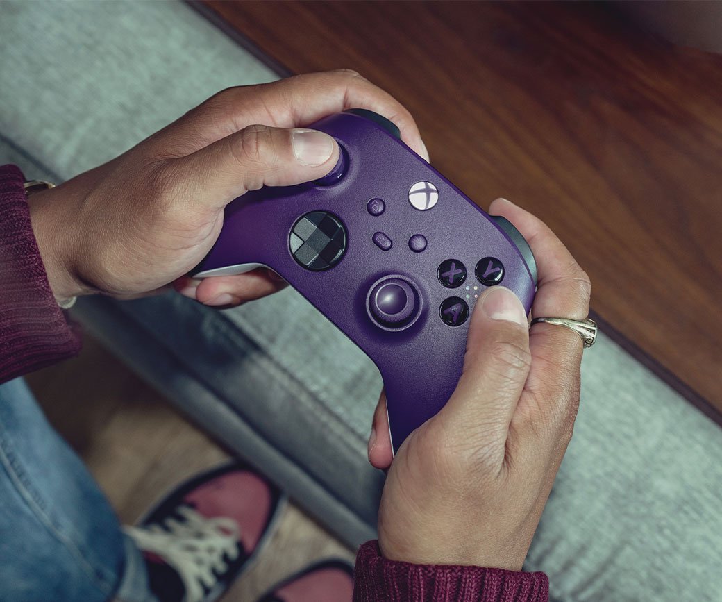 Player holding an Xbox Wireless Controller on a couch; image courtesy of Xbox